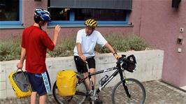 Joe chats with Michael at the entrance to Zurich Youth Hostel while preparing his bike for departure
