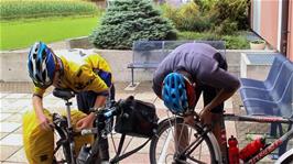 Tao makes adjustments to his brakes after already adjusting his hubs and headset outside Schaan youth hostel, while Joe just adjusts his brakes
