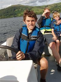 Freddie takes the controls of our hire boat on Lake Windermere